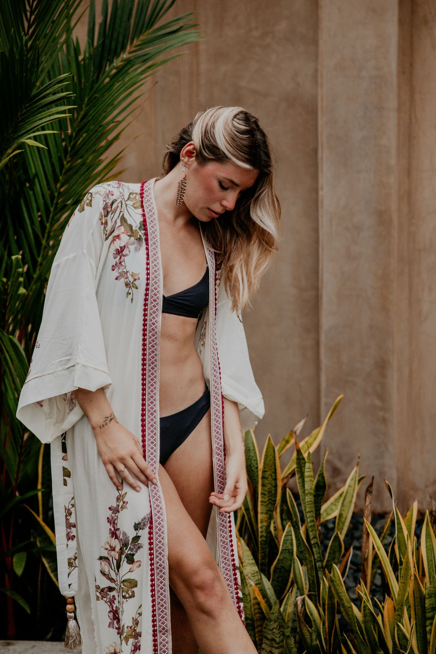 This white kimono with a cherry blossom print is gorgeous. We love the sassy side slits and the wide sleeves embellished with a golden thread. The neckline is enhanced by an elegant handwoven trim with traditional Moroccan cherry buttons.