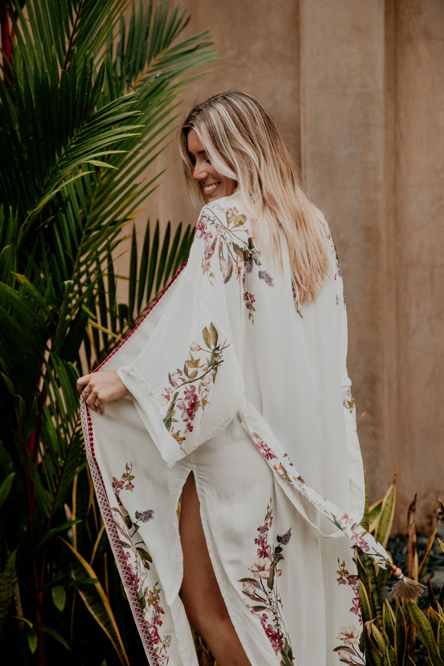 This white kimono with a cherry blossom print is gorgeous. We love the sassy side slits and the wide sleeves embellished with a golden thread. The neckline is enhanced by an elegant handwoven trim with traditional Moroccan cherry buttons.