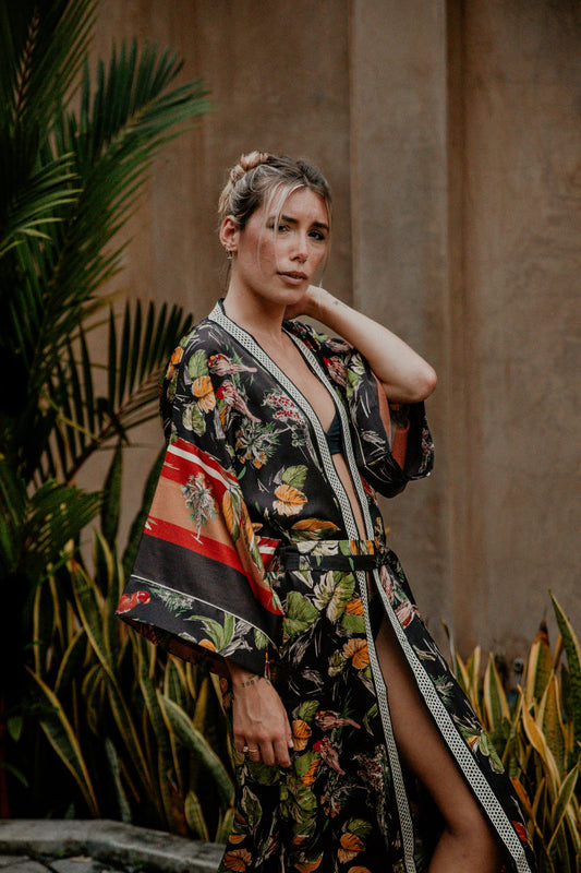 This silky kimono with wide sleeves is gorgeous. We love the combination of flower and bird prints that grant an imperial vibe to this kimono. The neckline is enhanced by an elegant handwoven silk trim.