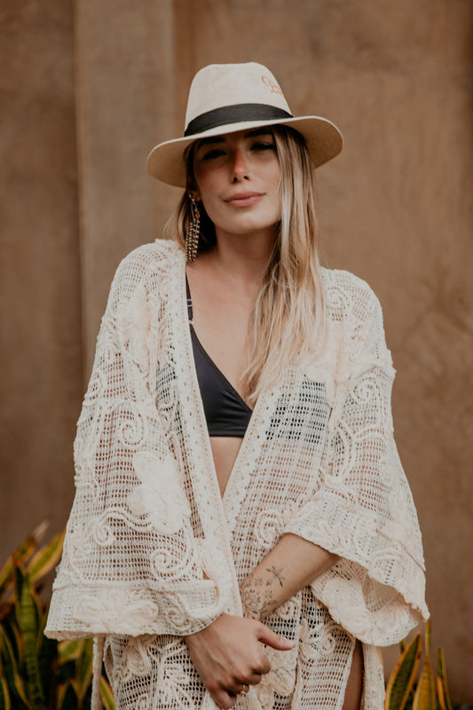 This macrame embroidered kimono is gorgeous. We love the sassy side slits, the wide sleeves and the delicate embroidered flowers that accentuate the Boho style of this kimono. The neckline is enhanced by an elegant handwoven trim.