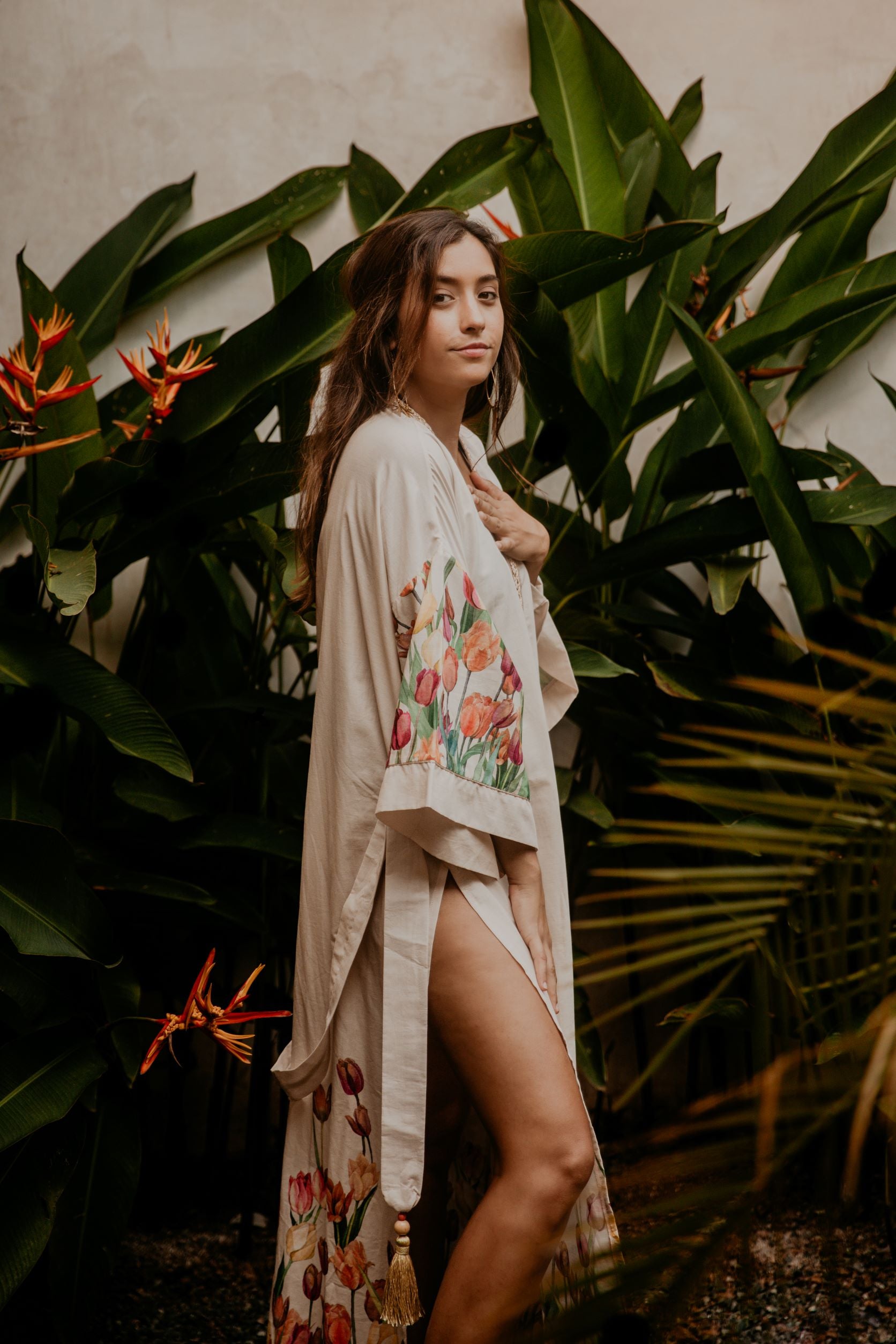 This heavenly pink flowery kimono is gorgeous. We love the sassy side slits and the wide sleeves embellished with a golden thread. The neckline is enhanced by an elegant handwoven silk trim.