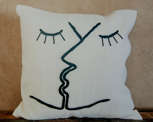 You will love this look-good, feel-good pillow. Hand-loomed and embroidered by skilled artisans with two kissing faces stitched on a cream ground