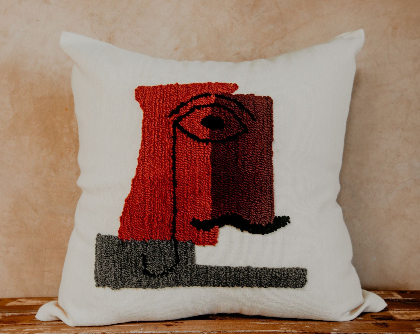 Asymmetric and colourful wool designs float across the cream space of this beautiful pillow to create an elegant man's face from another century.